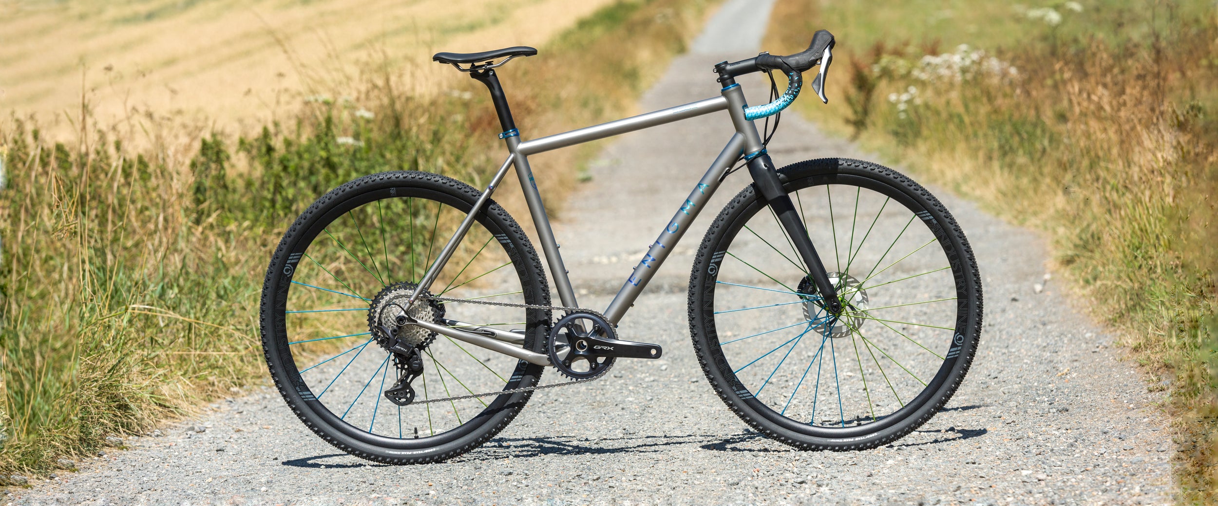 Enigma Edge Ti gravel bike – titanium frame with carbon gravel fork, shown with 700c wheels and flared drop bars, designed for fast off-road riding