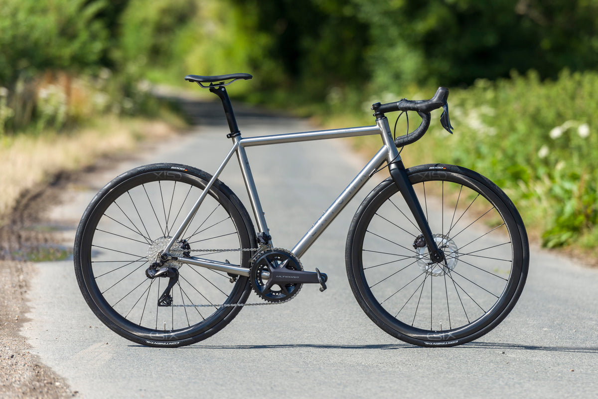 Side profile of the Enigma Elan titanium endurance frame with a hand-brushed finish, showcasing clean lines and classic UK-made craftsmanship