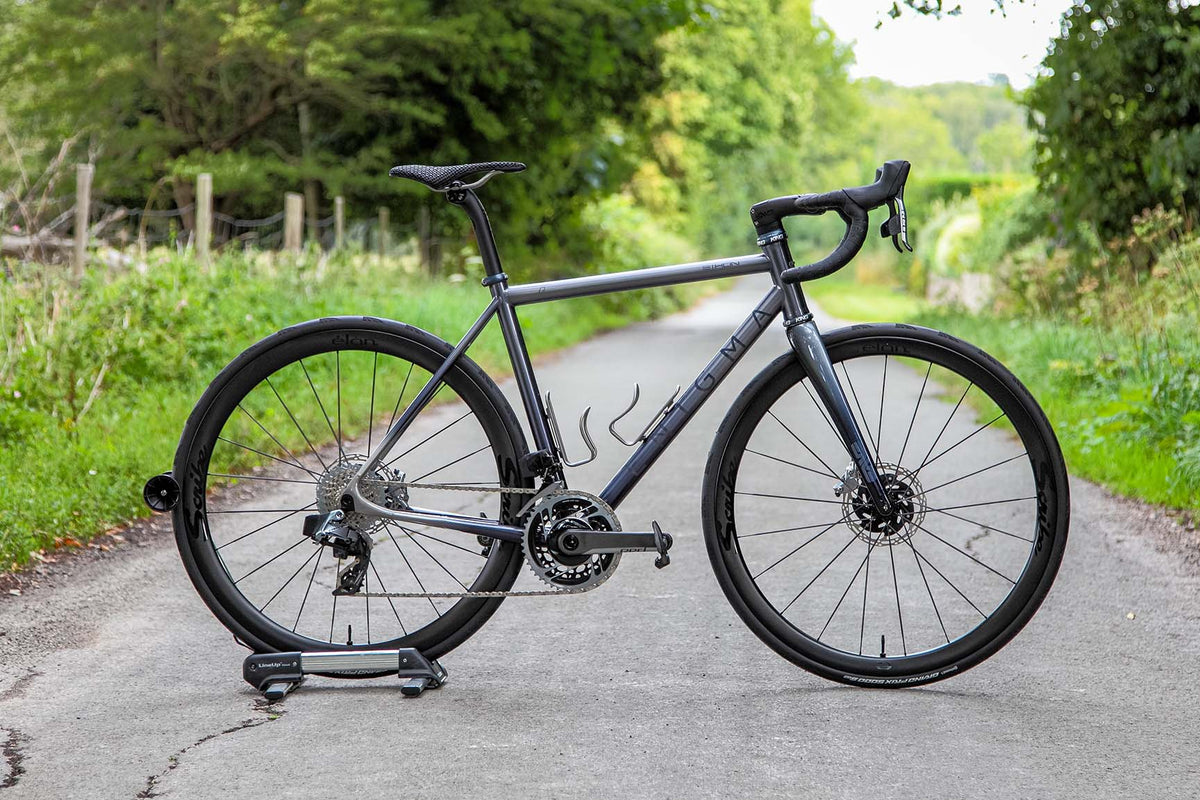 Enigma Signature Eikon titanium road bike in midnight blue photographed on a country lane