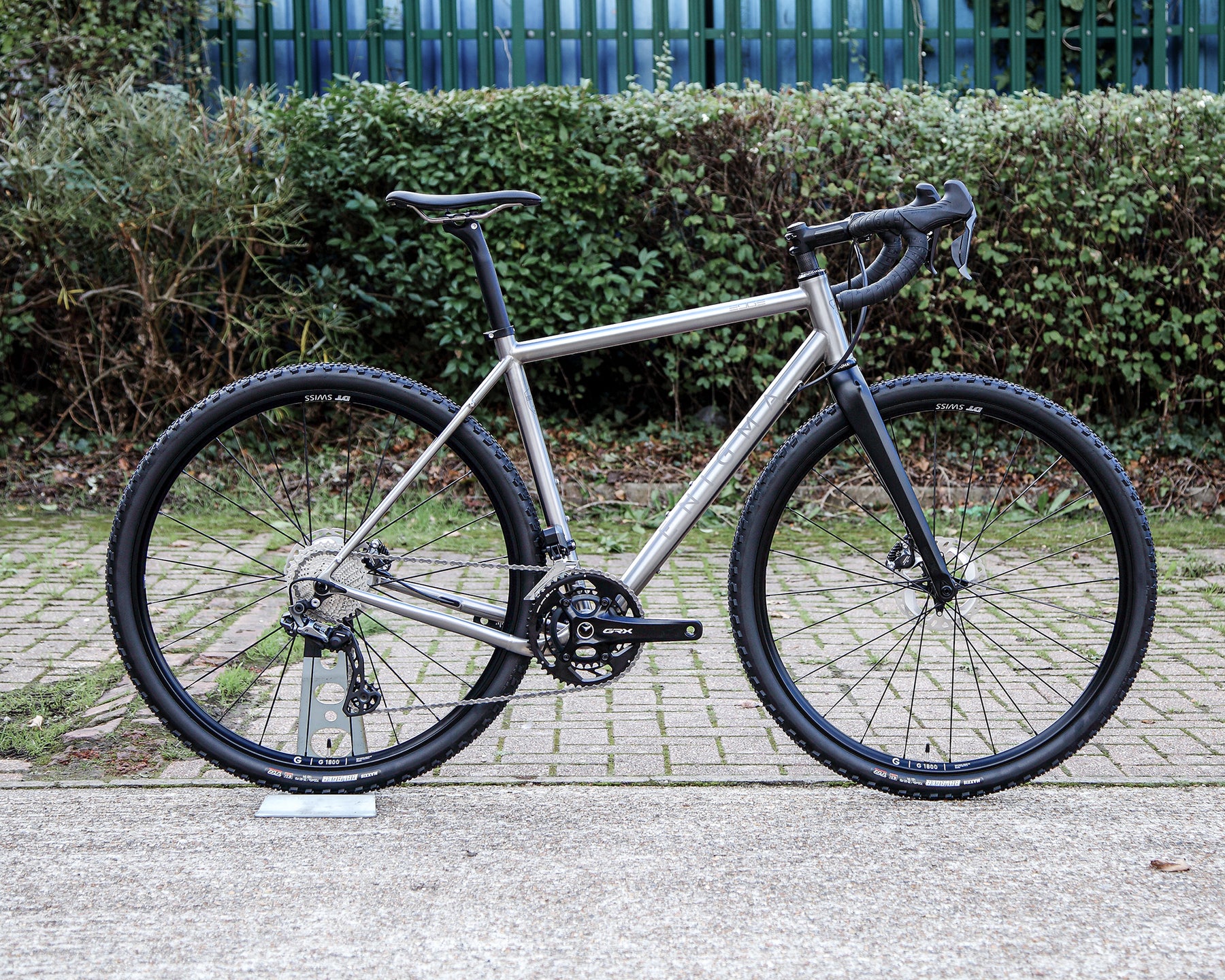 Enigma Edge MK.II titanium gravel bike, side profile showing brushed 3Al/2.5V titanium frame, Shimano GRX Di2 groupset, DT Swiss GR1800 wheels and C-Six carbon fork.