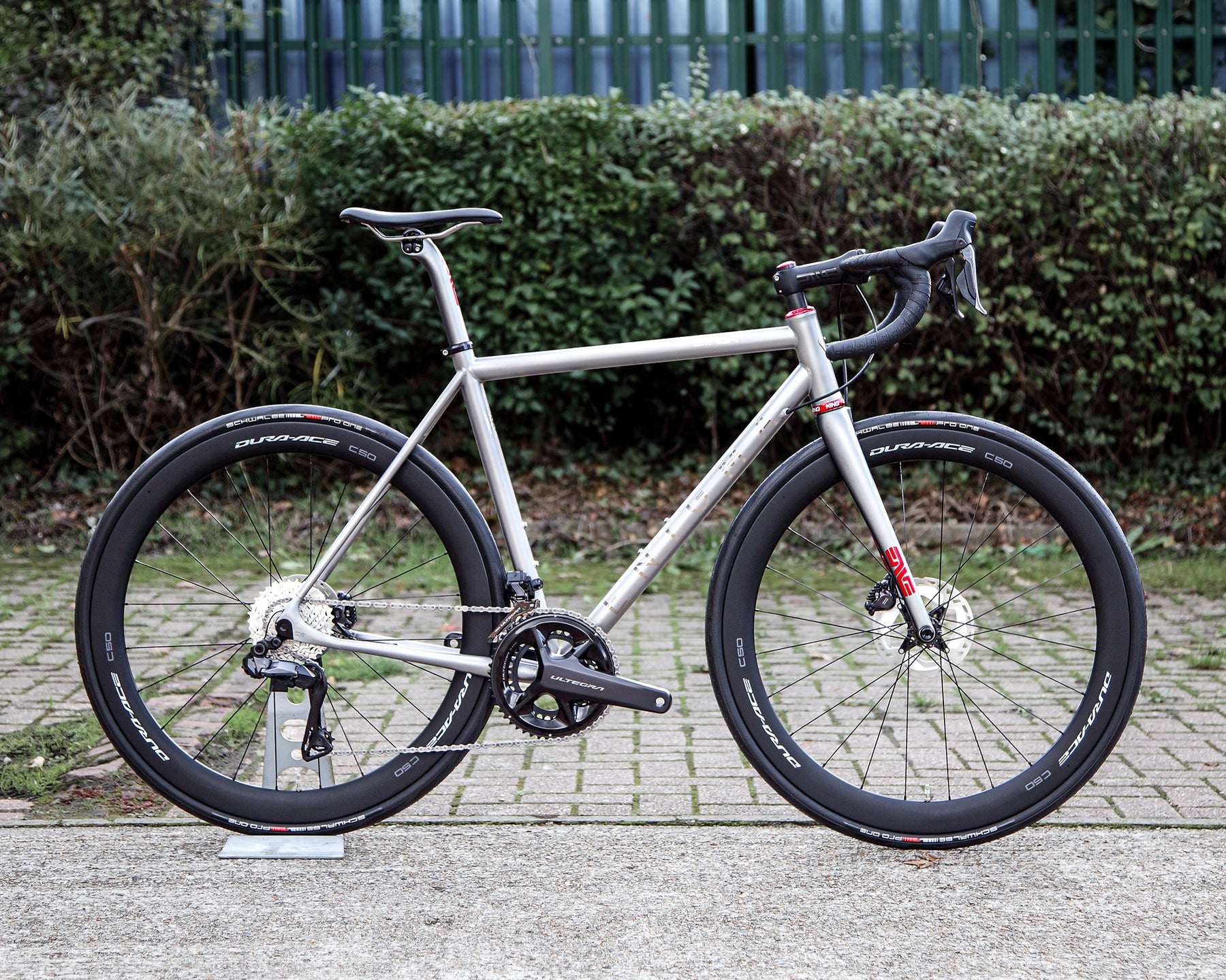 Enigma Eikon Signature 55cm titanium road bike with Shimano Ultegra Di2, Dura-Ace C50 carbon wheels, ENVE carbon components and polished red Chris King detailing.