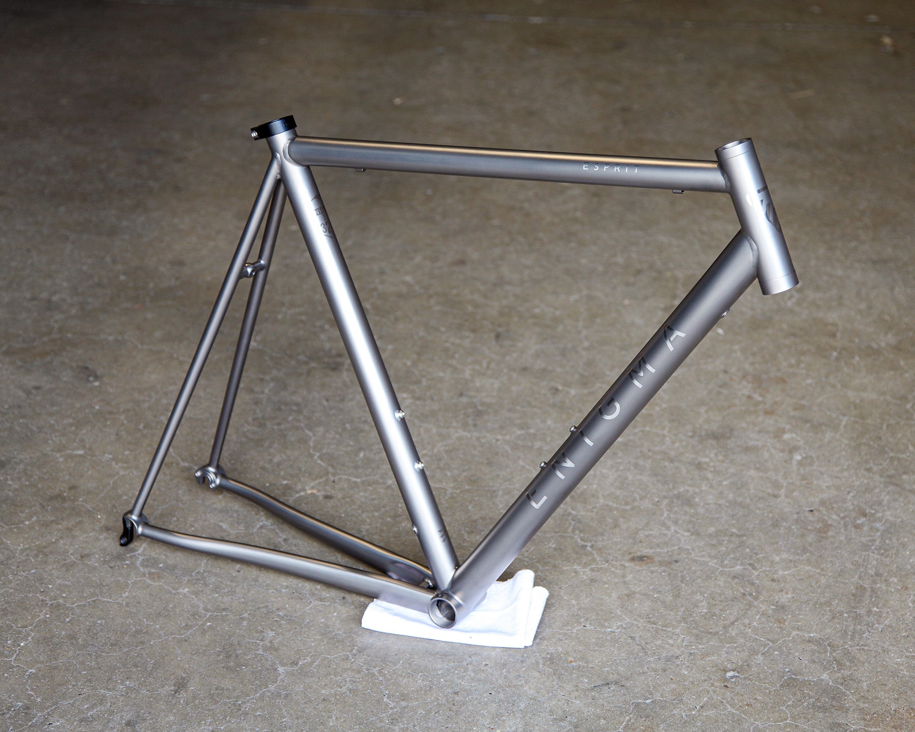 Enigma Esprit 56cm handcrafted titanium road frame with satin bead finish, brushed logos, traditional horizontal top tube and semi-internal Di2 routing.