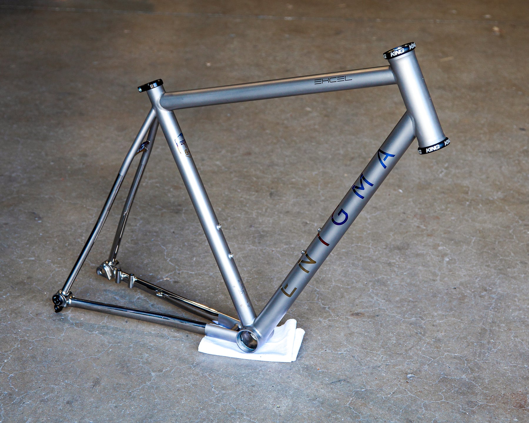 Enigma Excel AR Signature custom titanium road frame with satin bead finish, oil-slick anodised logos, mirror-polished rear triangle and Chris King headset.